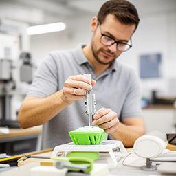Jonas Kehr beim Messen eines Prototyps in einer hellen Zürcher Werkstatt