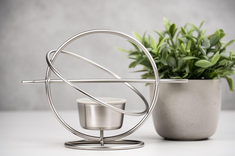 Orbit-Kollektion mit minimalistischen Ring-Designs aus Edelstahl und klaren Linien neben einer grünen Zimmerpflanze